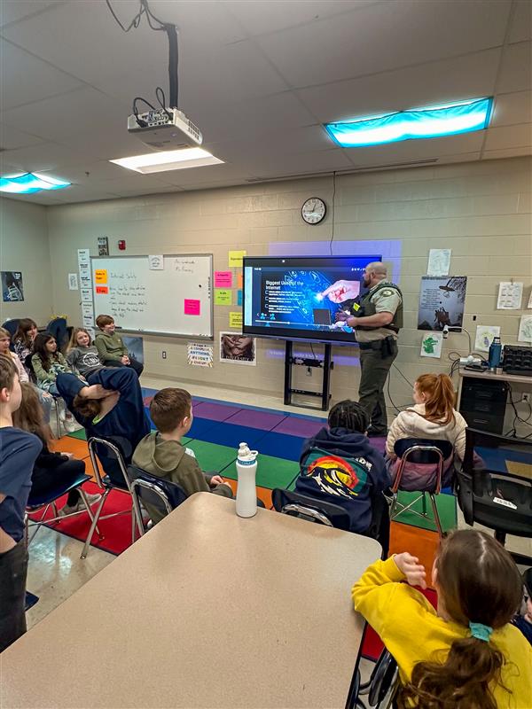 police officer talking to class of students
